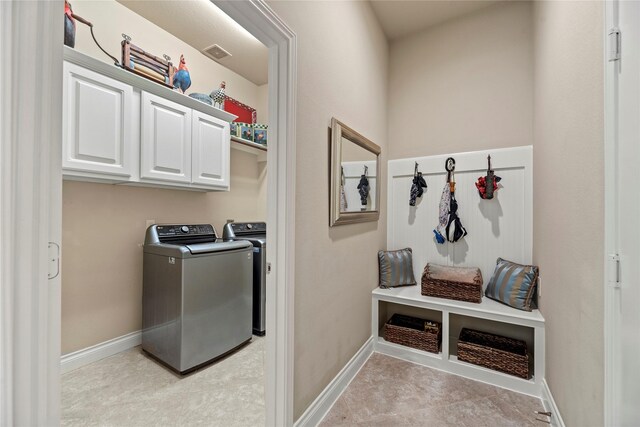 mudroom with washer and dryer, visible vents, and baseboards