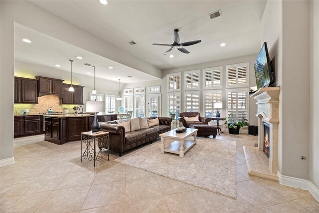 living area with visible vents, ceiling fan, and light tile patterned flooring