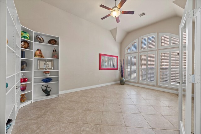 tiled spare room featuring visible vents, lofted ceiling, baseboards, and a ceiling fan