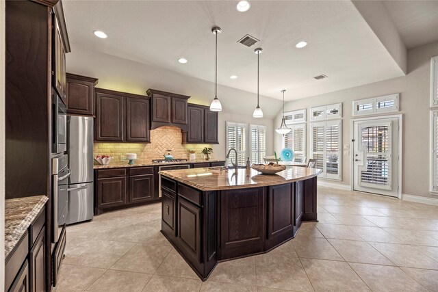 kitchen with light tile patterned floors, light stone countertops, visible vents, decorative backsplash, and appliances with stainless steel finishes