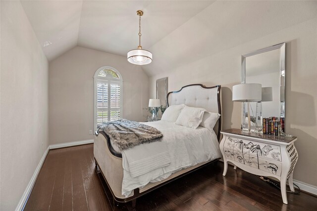 bedroom featuring baseboards, dark wood finished floors, and vaulted ceiling