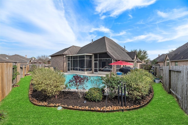 view of swimming pool with a lawn, a patio, a fenced backyard, and a sunroom