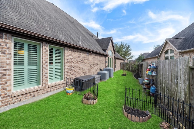 view of yard featuring central AC unit and a fenced backyard