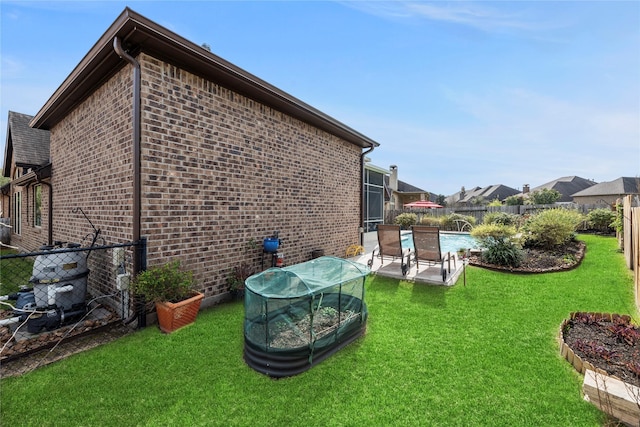 view of home's exterior with a patio, a fenced in pool, a yard, a fenced backyard, and brick siding