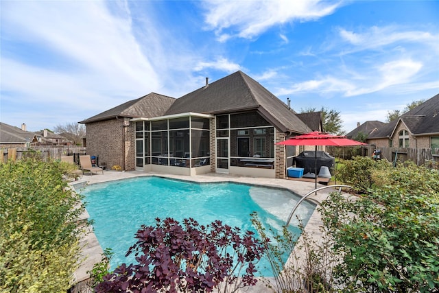 view of pool featuring a fenced backyard, grilling area, a sunroom, a fenced in pool, and a patio area