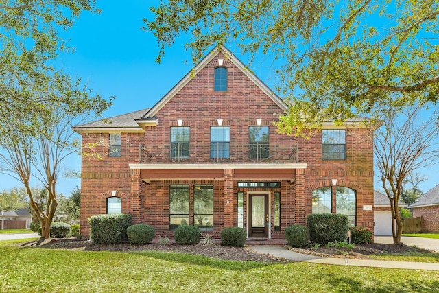 traditional-style home featuring brick siding and a front yard