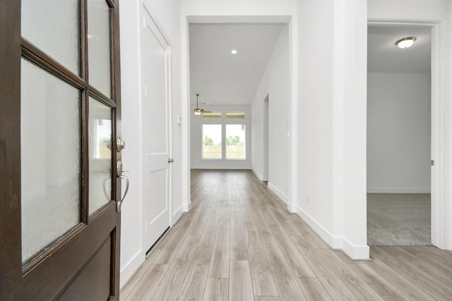 hall featuring light wood-style floors and baseboards