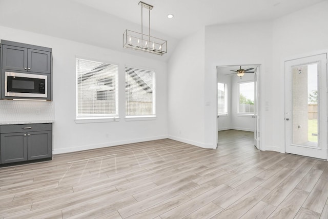 unfurnished dining area featuring baseboards, recessed lighting, ceiling fan, vaulted ceiling, and light wood-type flooring