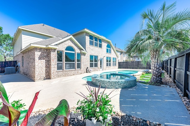 view of swimming pool featuring a pool with connected hot tub, a patio area, and a fenced backyard