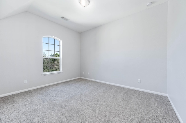 spare room with lofted ceiling, baseboards, visible vents, and carpet floors