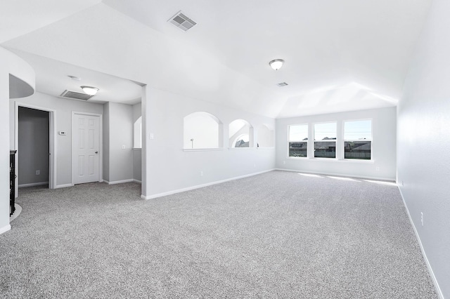 unfurnished living room with lofted ceiling, baseboards, visible vents, and carpet floors