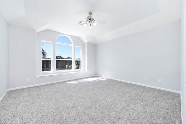 carpeted empty room with baseboards, a ceiling fan, and vaulted ceiling