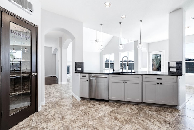 kitchen featuring arched walkways, ceiling fan, a sink, dishwasher, and dark countertops