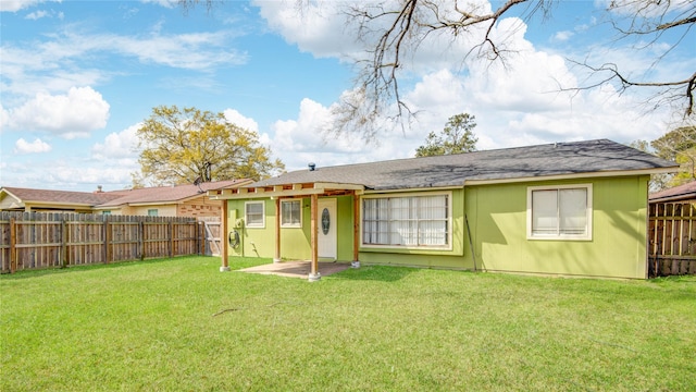 back of property with a lawn and a fenced backyard