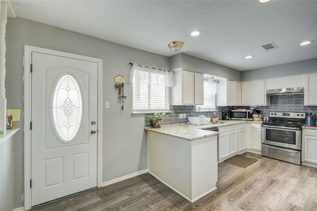 kitchen with visible vents, backsplash, stainless steel electric range oven, wood finished floors, and white cabinetry