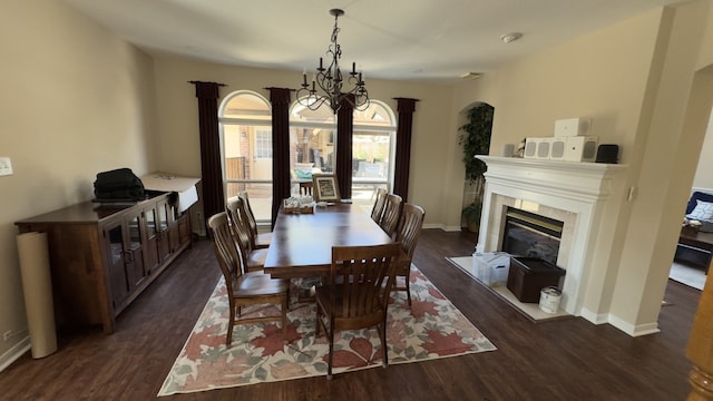 dining area with baseboards, dark wood-type flooring, and a fireplace