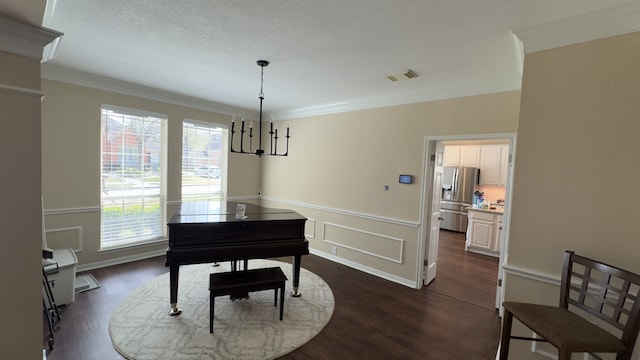 living area with dark wood finished floors, crown molding, a wainscoted wall, and a textured ceiling