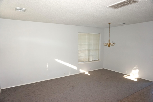 unfurnished room with a chandelier, visible vents, a textured ceiling, and carpet floors