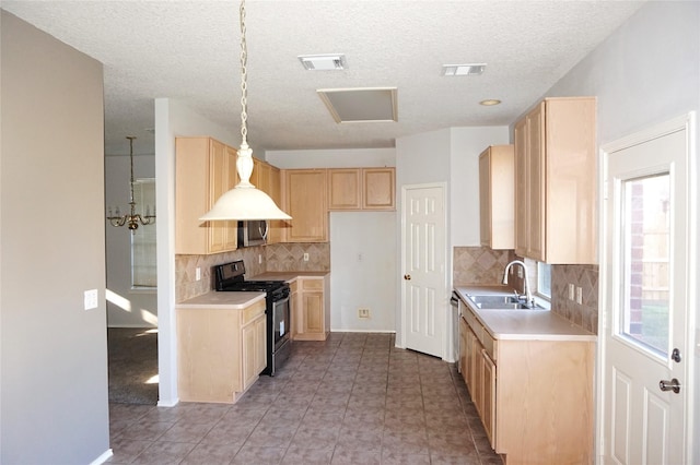 kitchen featuring visible vents, light brown cabinetry, light countertops, stainless steel appliances, and a sink