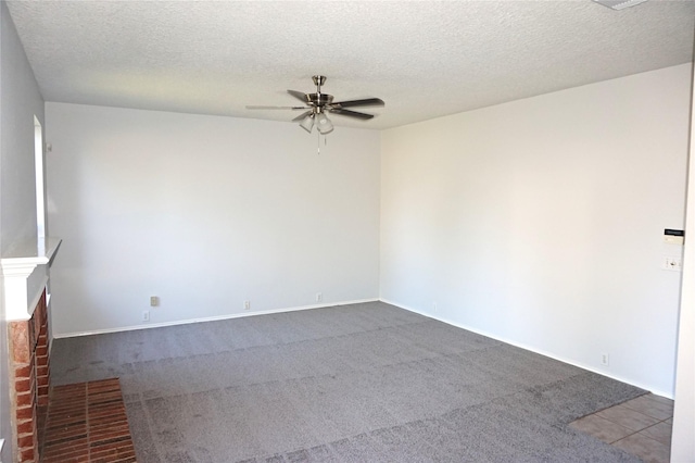 carpeted empty room featuring a textured ceiling and a ceiling fan