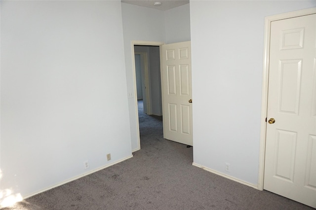 carpeted empty room featuring baseboards