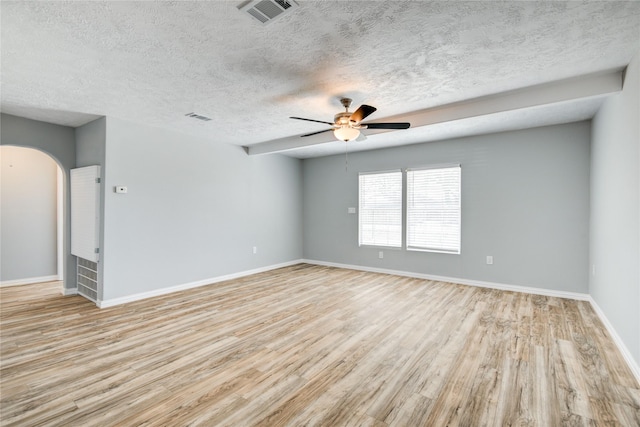 unfurnished room featuring visible vents, wood finished floors, arched walkways, baseboards, and ceiling fan