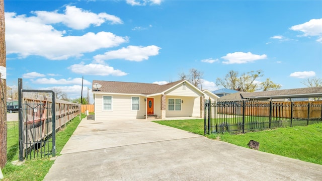 view of front of property with a fenced front yard, driveway, and a front lawn