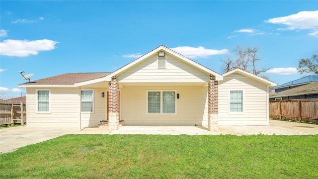 back of property with a yard, fence, and a patio area