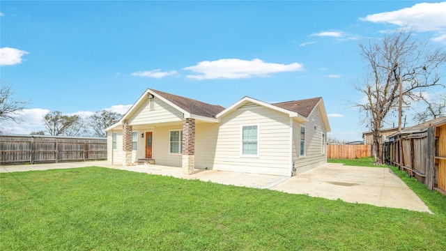 rear view of house featuring a fenced backyard, a lawn, and a patio