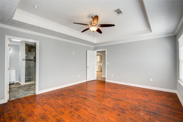 unfurnished bedroom featuring a raised ceiling, hardwood / wood-style flooring, visible vents, and ornamental molding