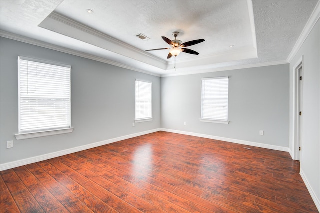 spare room with hardwood / wood-style floors, a raised ceiling, visible vents, and ceiling fan