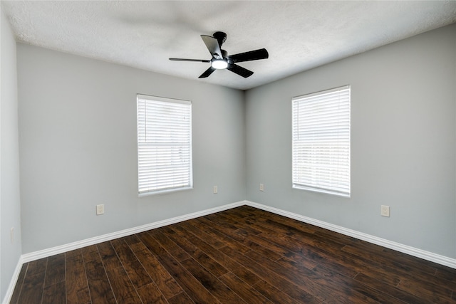 unfurnished room featuring dark wood finished floors, baseboards, and a wealth of natural light