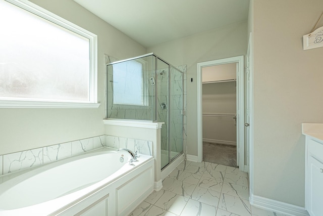 full bathroom featuring a walk in closet, marble finish floor, a stall shower, a bath, and vanity