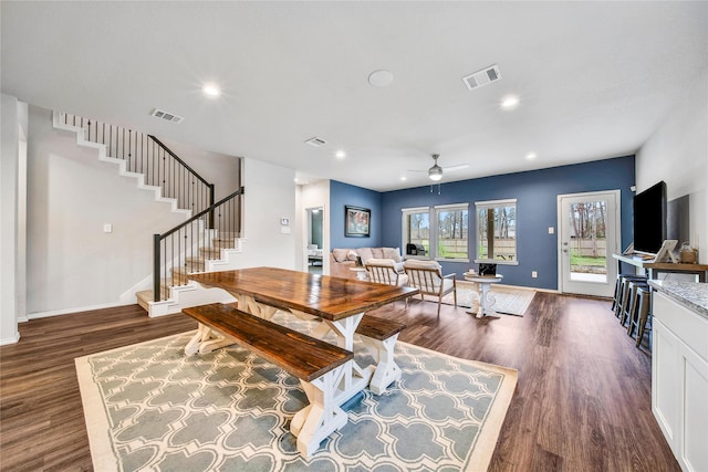 dining area with visible vents, baseboards, ceiling fan, dark wood finished floors, and stairway