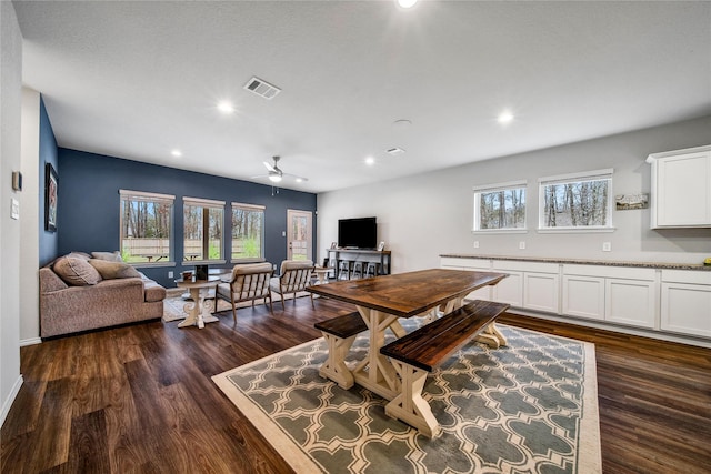 dining space with dark wood-type flooring, plenty of natural light, and a ceiling fan