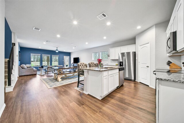 kitchen with open floor plan, appliances with stainless steel finishes, dark wood-type flooring, and visible vents