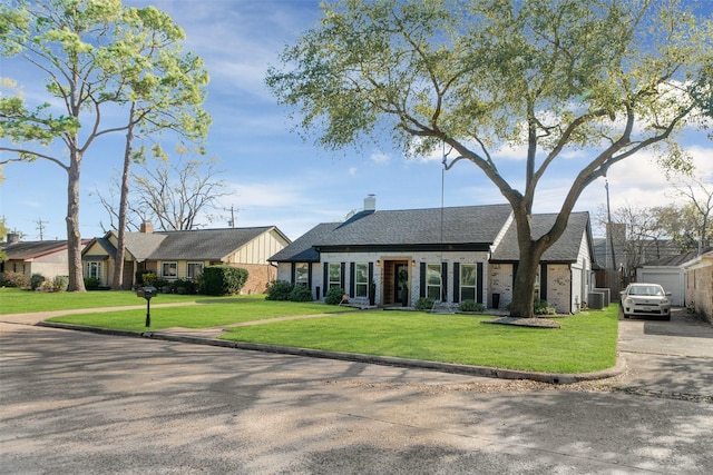 view of front facade with driveway, brick siding, and a front lawn