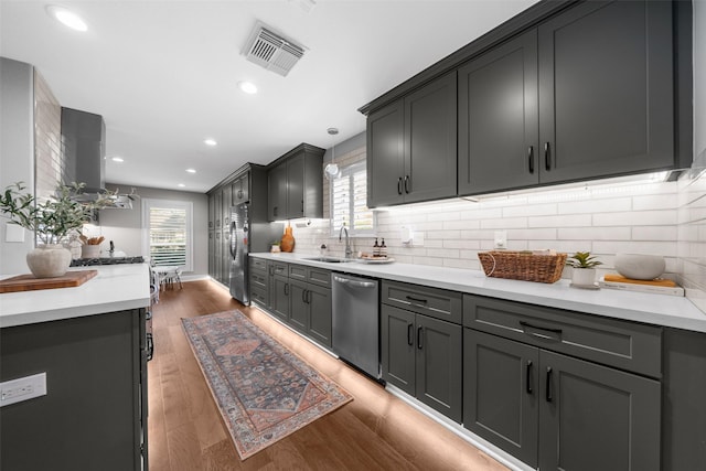 kitchen featuring visible vents, a sink, light countertops, light wood-style floors, and appliances with stainless steel finishes