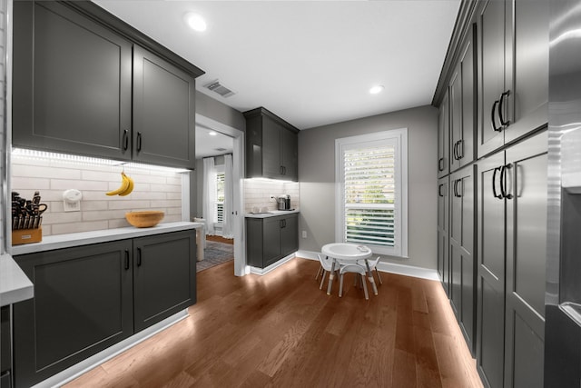 kitchen featuring visible vents, a healthy amount of sunlight, light countertops, and dark wood-type flooring