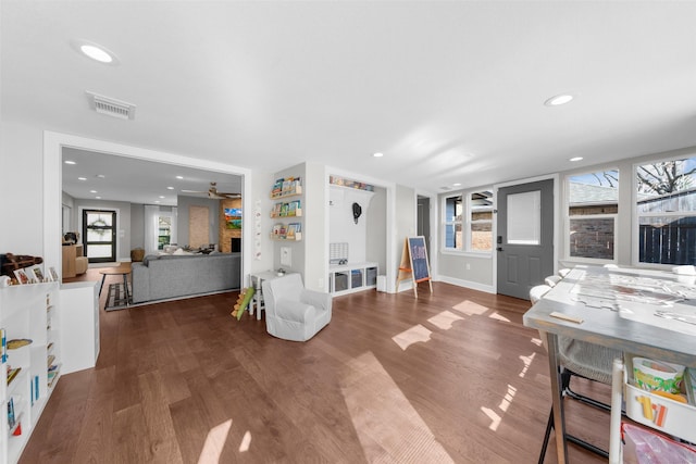 living area with recessed lighting, visible vents, and wood finished floors