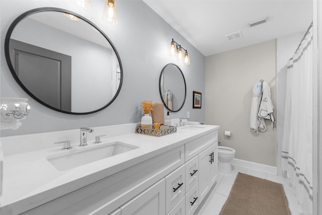 bathroom featuring double vanity, toilet, visible vents, and a sink