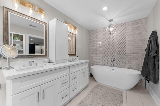 bathroom featuring tile patterned floors, a freestanding tub, double vanity, and a sink