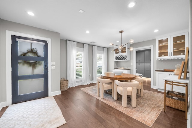 dining area featuring dark wood finished floors, a notable chandelier, recessed lighting, and baseboards