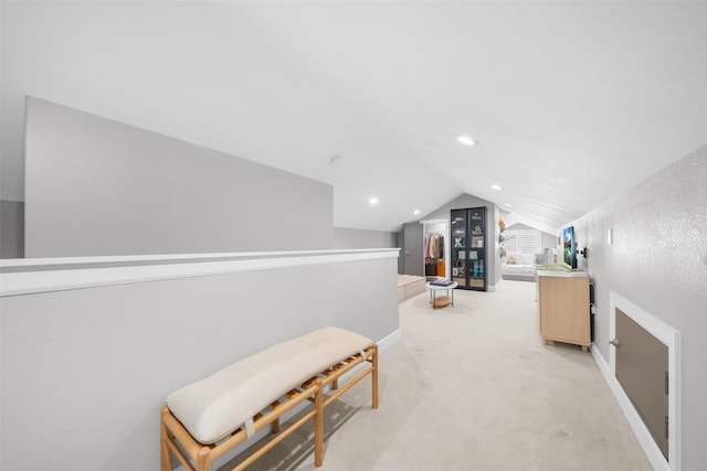 hallway with recessed lighting, baseboards, lofted ceiling, and light colored carpet