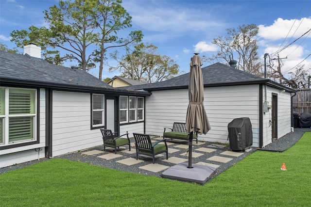 back of house with a patio, fence, a yard, a shingled roof, and a chimney