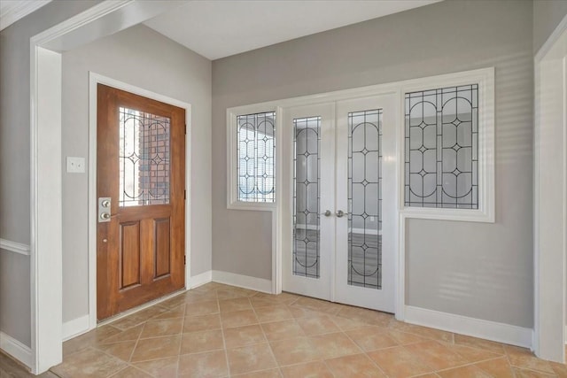 entryway with light tile patterned flooring, french doors, and baseboards