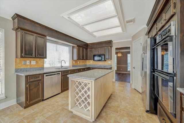 kitchen with visible vents, a center island, ornamental molding, black appliances, and a sink