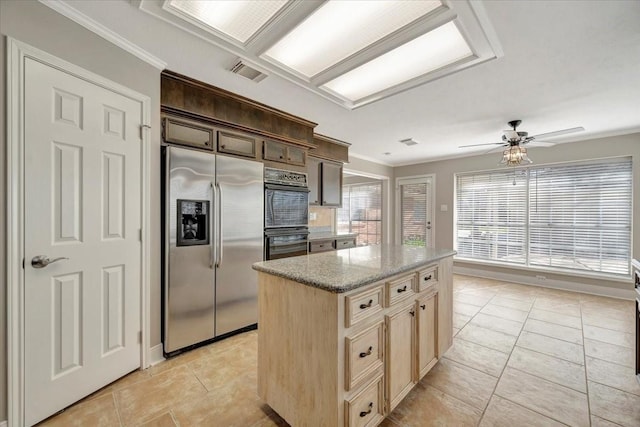 kitchen with visible vents, a center island, light stone countertops, stainless steel fridge, and dobule oven black