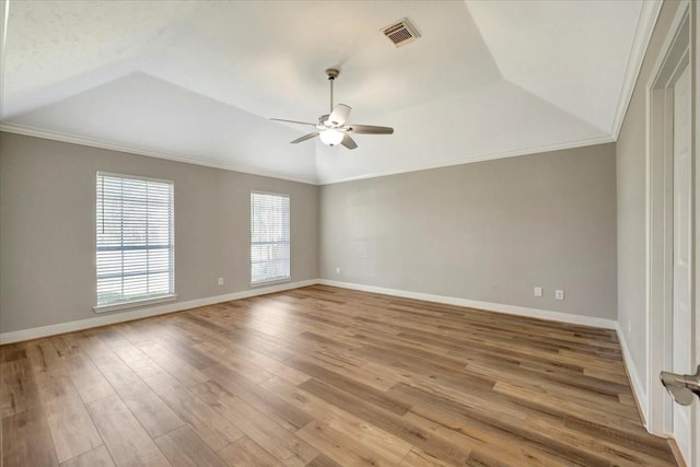 spare room featuring wood finished floors, visible vents, lofted ceiling, ceiling fan, and crown molding