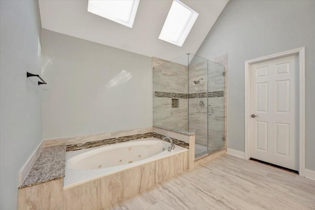 bathroom featuring lofted ceiling with skylight, a jetted tub, and a shower stall